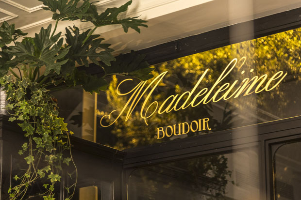 Vetrine Madeleine Boudoir: ristorante gastronomico. Insegna dorata, piante decorative. Cucina raffinata, atmosfera accogliente.