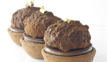 Dolcetti al cioccolato artigianali con foglia d'oro. Pasticceria raffinata, dessert goloso.