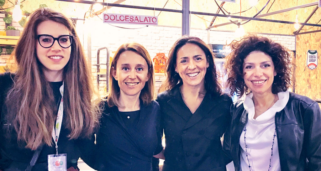 Quattro donne sorridenti a Dolcesalato. Team building, evento aziendale, networking professionale.