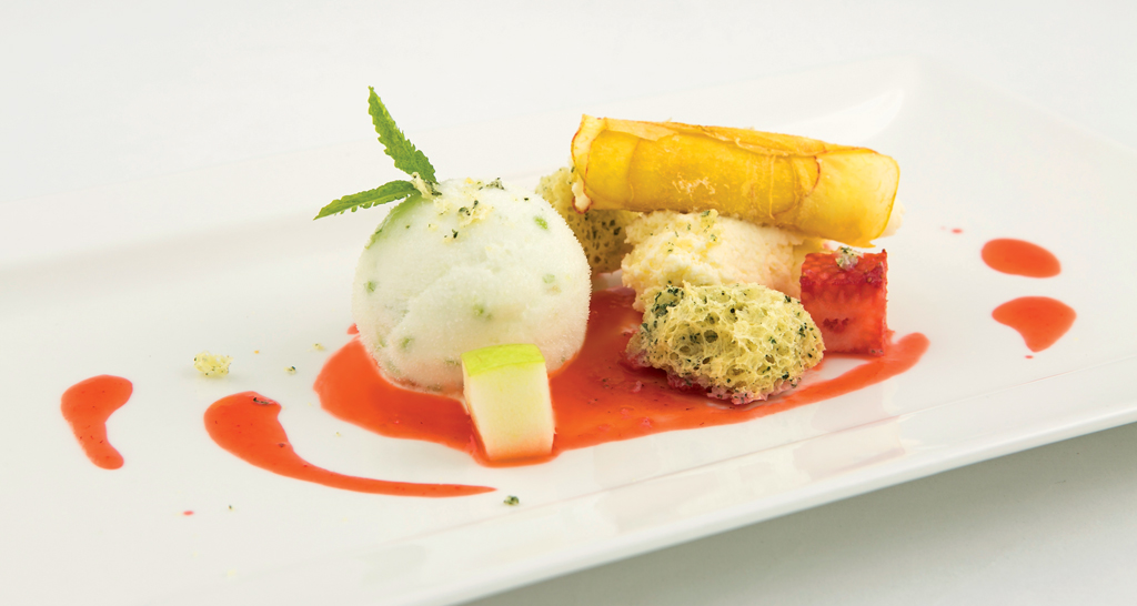 Dolce gourmet: gelato, frutta fresca e salsa rossa su piatto bianco. Dessert elegante.