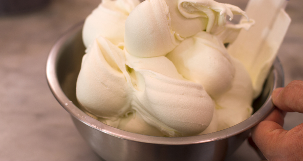 Gelato all'olio extra vergine d'oliva in ciotola d'acciaio. Dessert cremoso e artigianale.