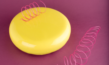 Dolce giallo lucido con decorazioni rosa. Pasticceria moderna, dessert elegante.