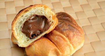 Croissant al cioccolato. Pasticceria dolce con ripieno cremoso. Colazione golosa.