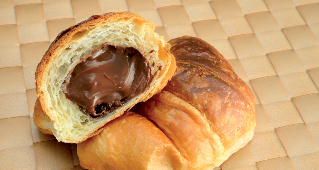 Croissant al cioccolato. Pasticceria dolce con ripieno cremoso. Colazione golosa.