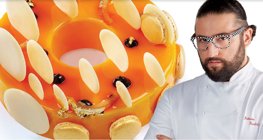 Chef Rinaldini con torta arancione. Pasticceria artigianale, macarons e decorazioni.