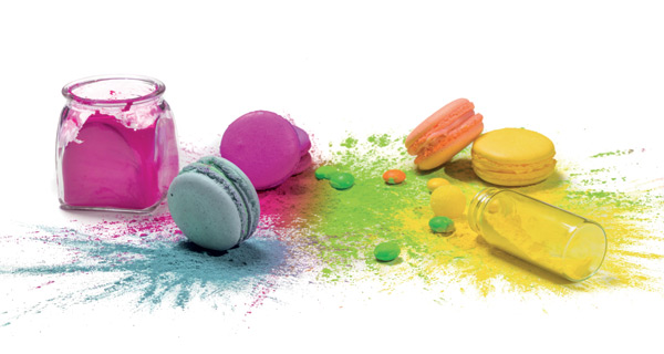 Coloranti alimentari e macarons colorati. Barattoli con polveri e dolcetti assortiti.