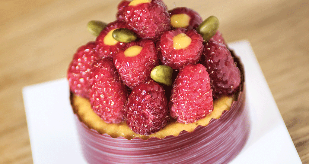 Dolce ai lamponi e pistacchi. Dessert artigianale con frutta fresca.