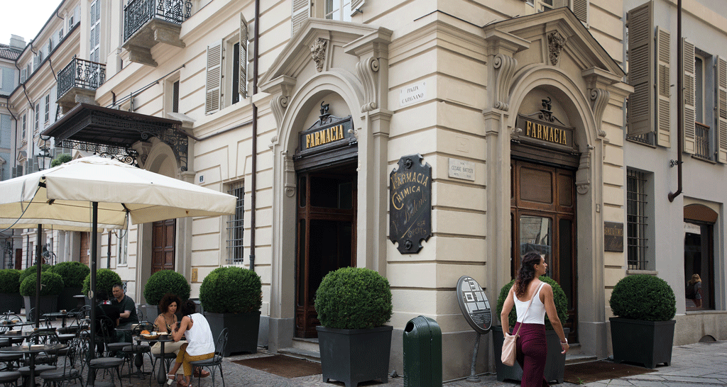 Farmacia storica a Torino, Piazza Carignano. Architettura elegante e dehors con tavolini.