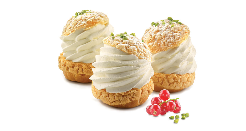 Deliziosi bignè alla crema con granella di pistacchio. Dessert invitante, pasticceria artigianale.