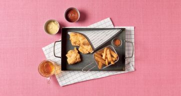 Fish and chips croccante su vassoio con salse. Street food inglese, patatine fritte e merluzzo impanato.