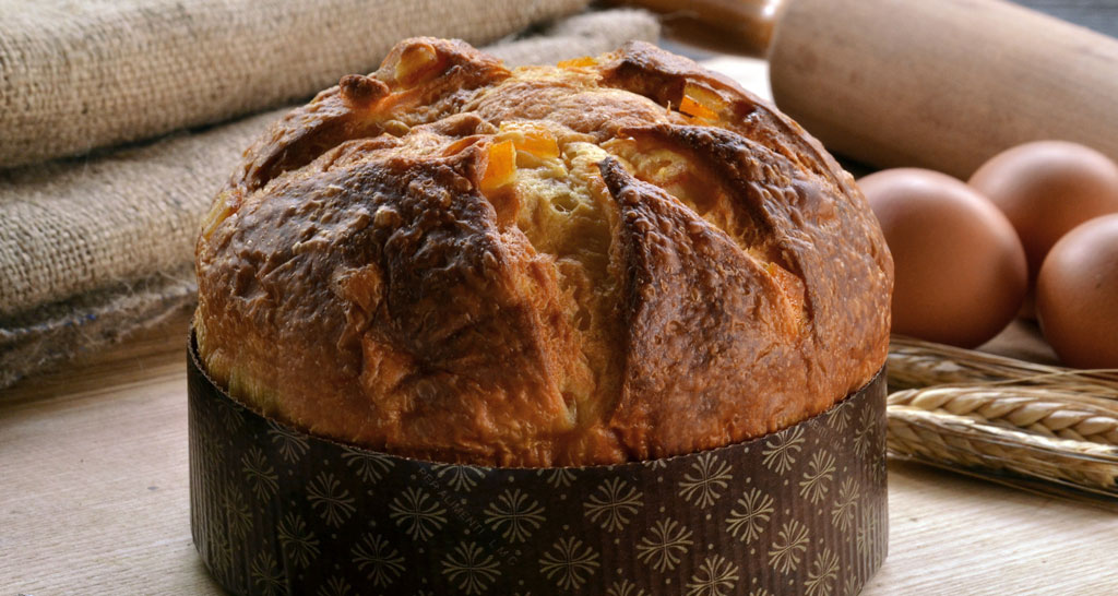 Panettone artigianale con uova fresche e farina. Dolce tradizionale italiano, ideale per Natale e feste.