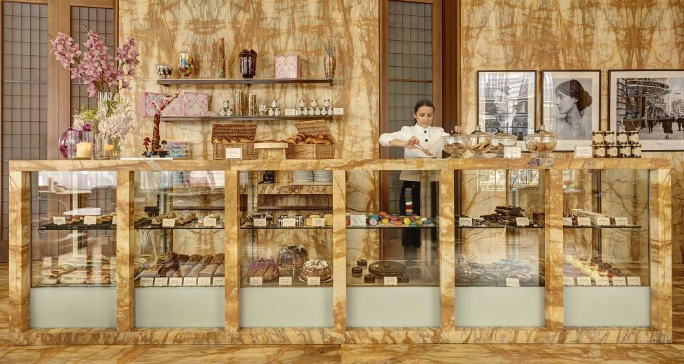 Caffè Royal, Londra. Vetrina pasticceria con dolci, torte e macarons. Arredamento lussuoso, marmo e fiori.
