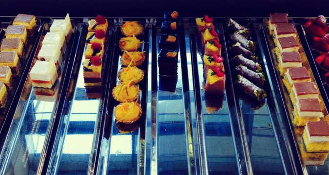 Vetrina di pasticceria con dolci assortiti: torte, cannoli siciliani e tartellette. Delizie per il palato!