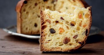 Fetta di panettone artigianale con uvetta e canditi. Dolce tipico natalizio italiano.