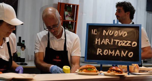 Preparazione del nuovo maritozzo romano. Chef e cartello Il nuovo maritozzo romano. Specialità culinaria romana.