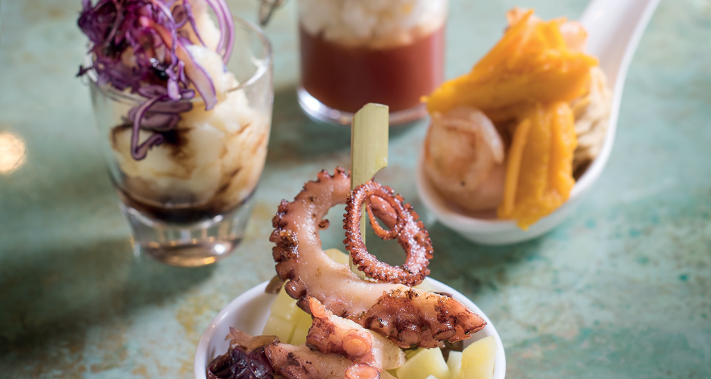 Aperitivo gourmet con polpo, verdure e salse. Assortimento di stuzzichini per un'esperienza culinaria unica.