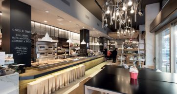 Interni di panetteria e pizzeria. Arredamento moderno, illuminazione creativa, forno a legna. Design accogliente.