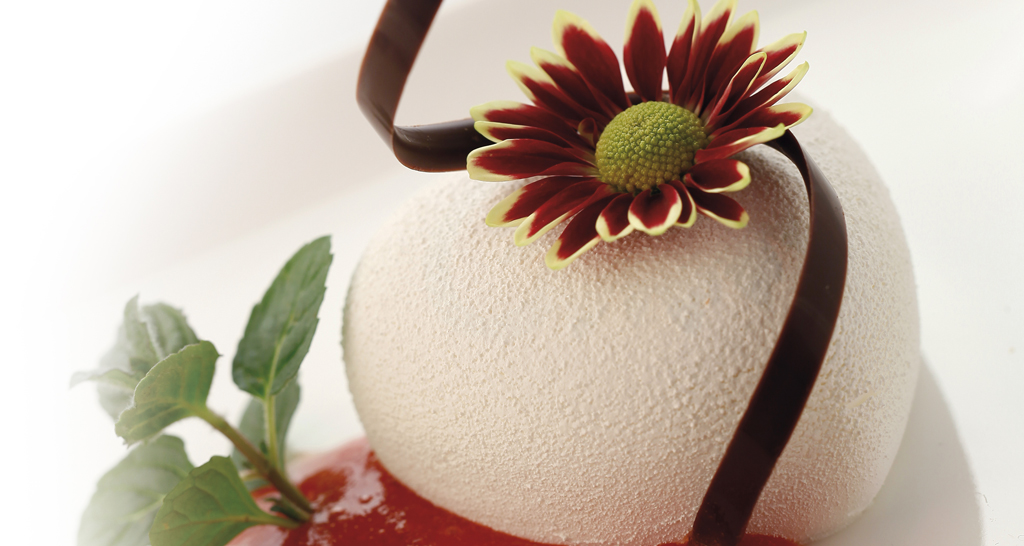 Dolce monoporzione con fiore, cioccolato e salsa di frutta. Dessert elegante e raffinato.