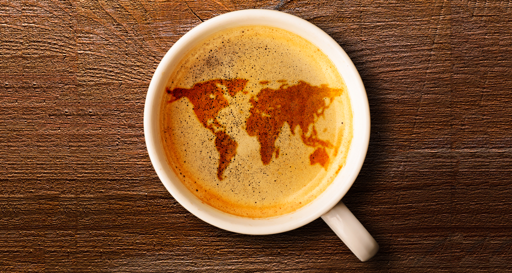 Tazza di caffè con mappa del mondo. Bevanda calda su legno. Coffee break.
