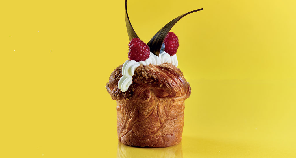 Dolce sfogliato con crema, lamponi freschi e decorazioni. Pasticceria artigianale, dessert goloso.