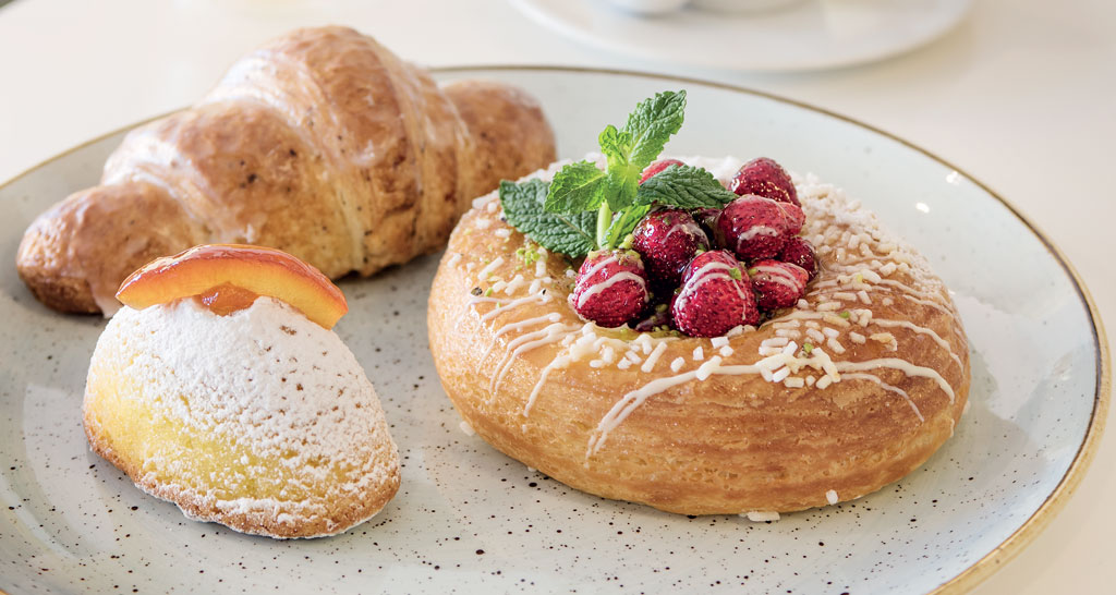 Colazione Morlacchi: croissant, brioche con fragole e pasticcino con zucchero a velo.
