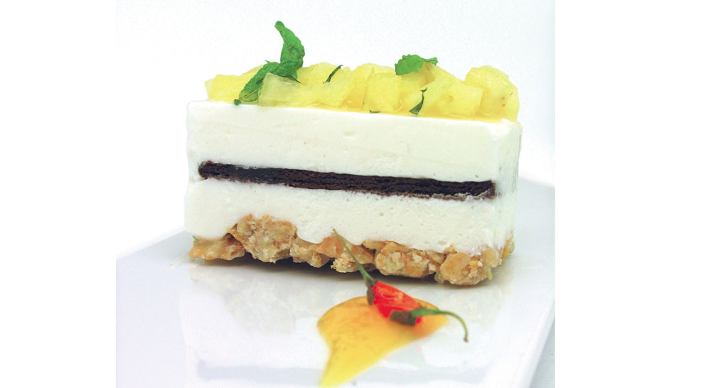 Dolce finger food: torta a strati con ananas e menta, guarnita con peperoncino. Dessert originale.