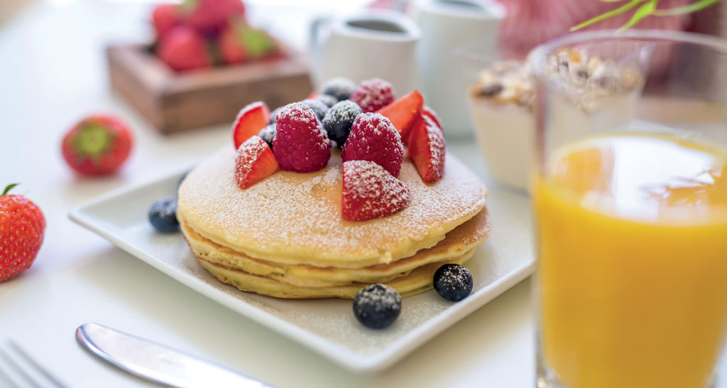 Pancake con frutti di bosco e zucchero a velo. Colazione gustosa.