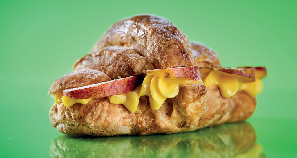 Croissant integrale tagliato con crema e frutta. Pasticceria artigianale, colazione sana.