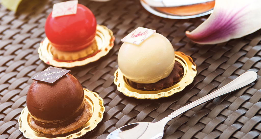 Dolci bavaresi assortiti su piattini dorati. Pasticceria artigianale, dessert elegante.