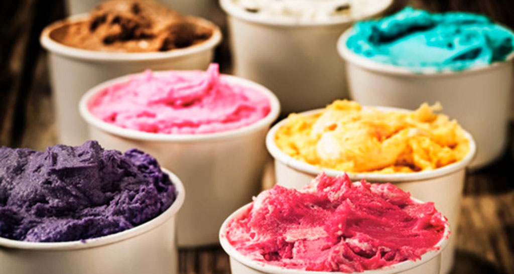 Gelato artigianale colorato in vaschette. Assortimento di gusti, dessert estivo.