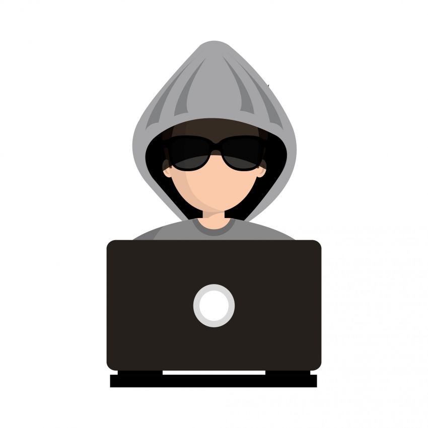 Hacker con cappuccio e occhiali da sole che usa un laptop. Sicurezza informatica.