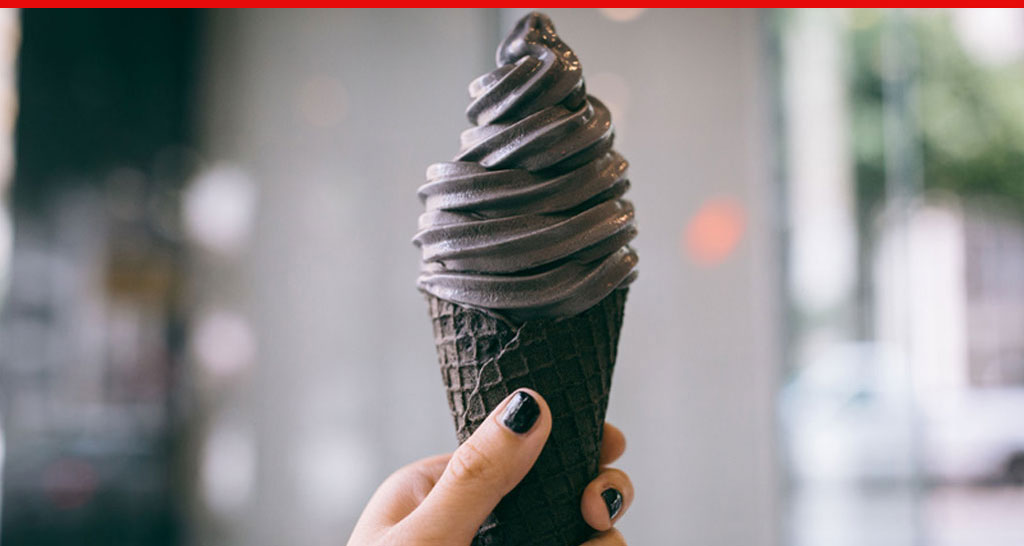 Gelato nero in cono nero. Dessert originale, cibo goloso.