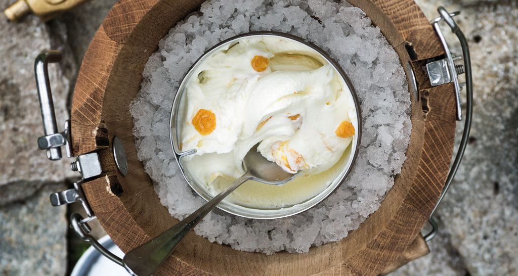 Gelato artigianale in tino di legno con ghiaccio. Cucchiaio nel gelato.