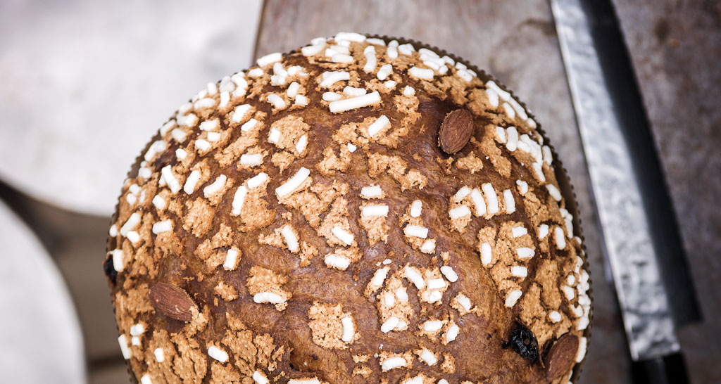 Panettone artigianale con glassa di zucchero e mandorle. Dolce natalizio italiano.