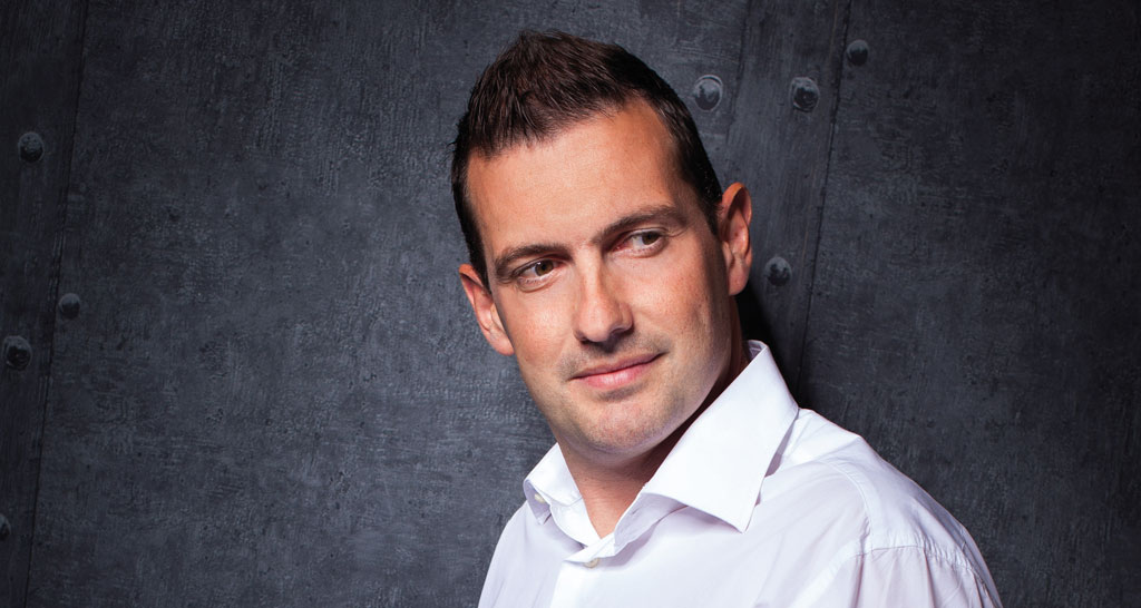 Uomo in camicia bianca. Ritratto di persona sorridente con capelli corti.