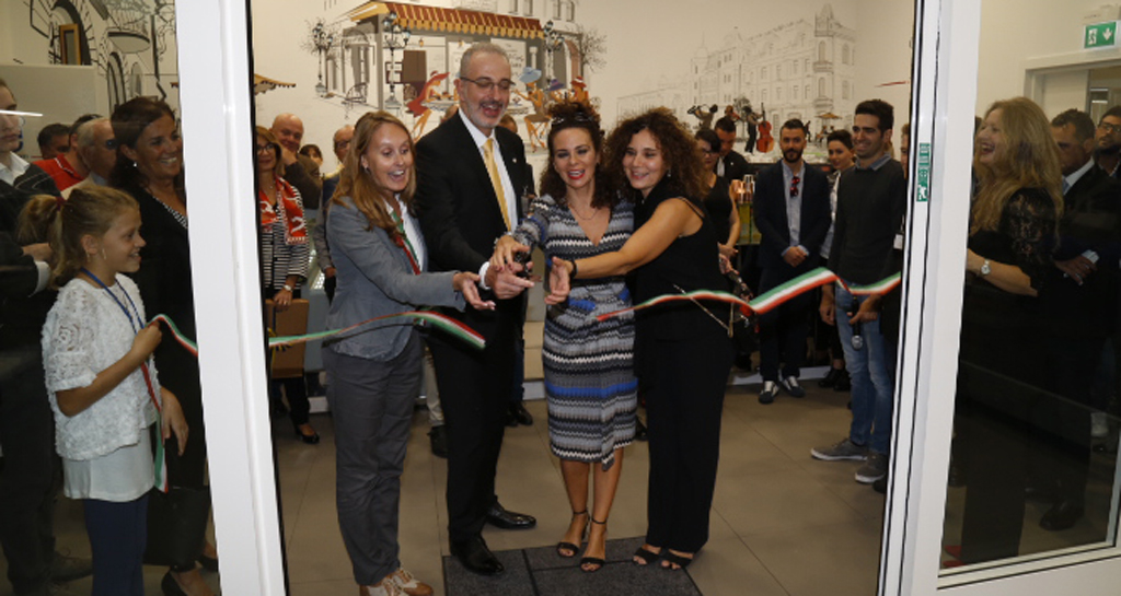 Inaugurazione evento: persone tagliano il nastro tricolore. Celebrazione, pubblico, festeggiamenti.