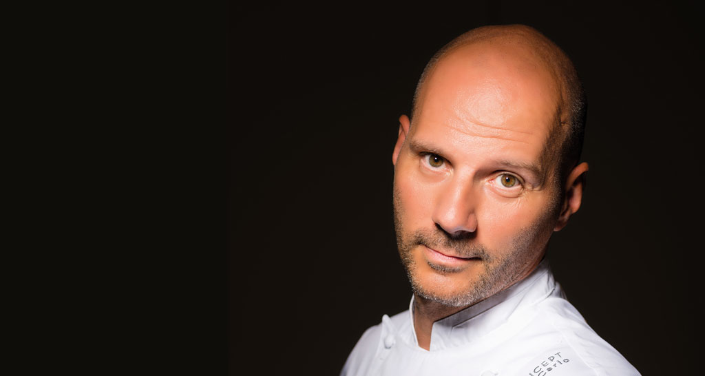 Ritratto dello chef calvo in divisa bianca. Cucina gourmet e ristorazione.