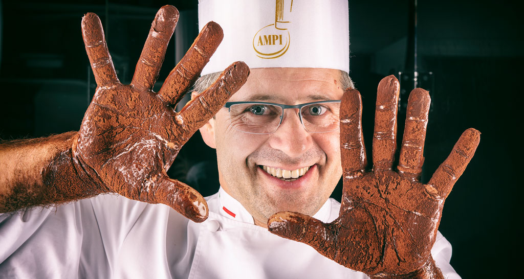Chef Cortinovis con mani sporche di cioccolato. Pasticceria artigianale.