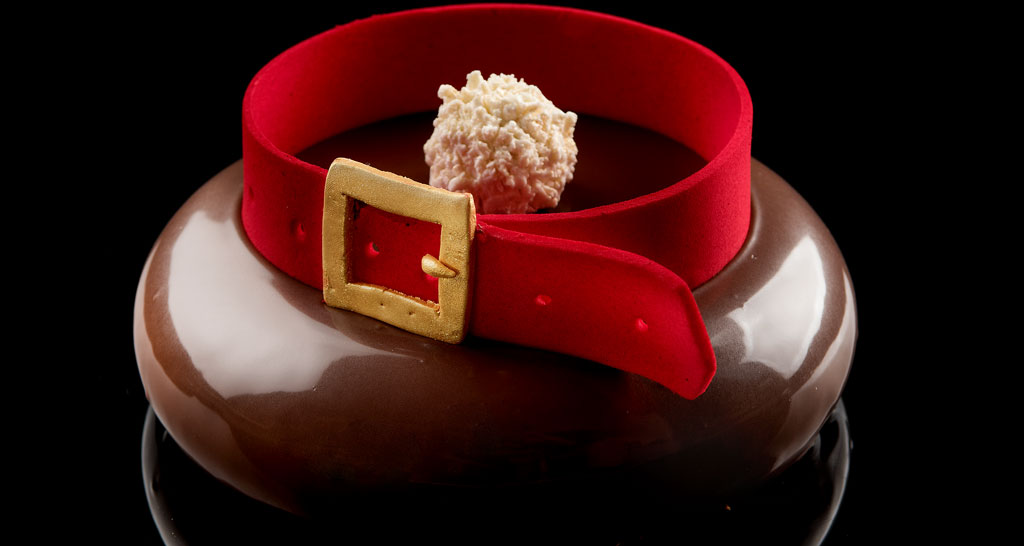 Mousse al cioccolato a forma di Babbo Natale con cintura rossa e fibbia dorata. Dessert natalizio.