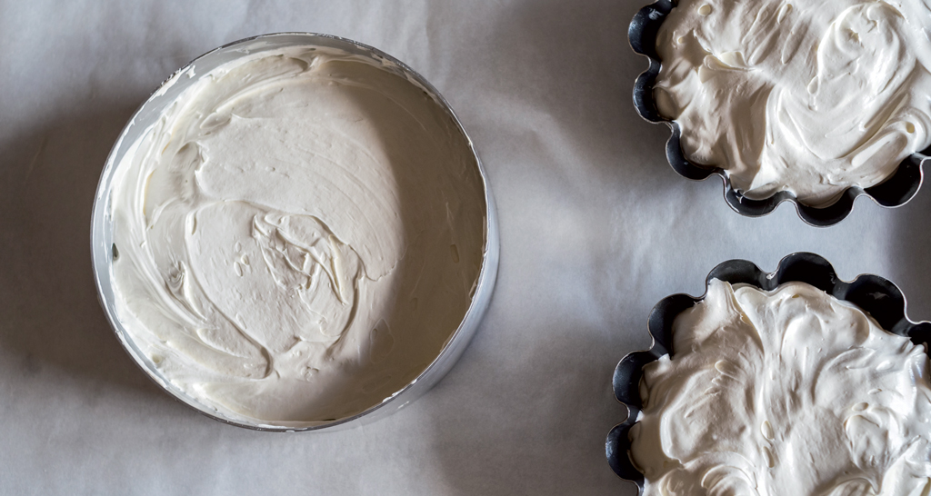 Torte con crema bianca in stampi. Dolci fatti in casa, dessert cremosi.