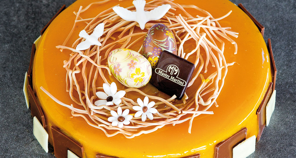 Torta di Pasqua con mousse all'arancia, uova di cioccolato decorative e colomba bianca. Dolce pasquale.