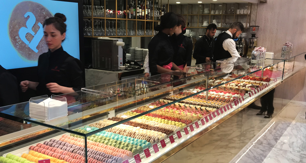 Pasticceria Rinaldini: vetrina con macarons colorati e dolci assortiti. Personale al lavoro.