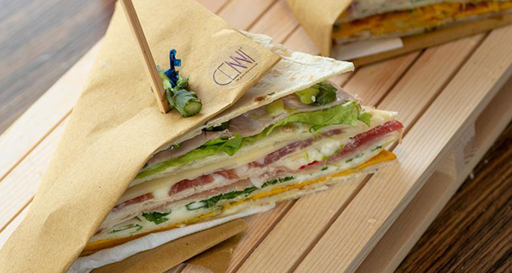 Club sandwich con piadina romagnola. Farcito con prosciutto, formaggio e verdure fresche. Ottimo per un pranzo veloce.