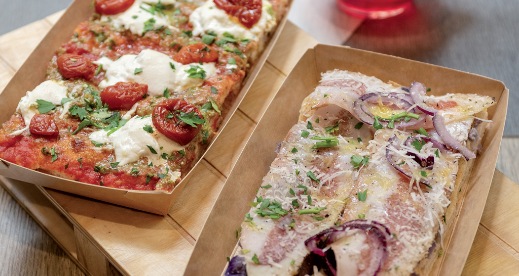 Pizza romana farcita in teglia. Pomodorini, mozzarella, cipolla rossa e guanciale. Street food italiano.