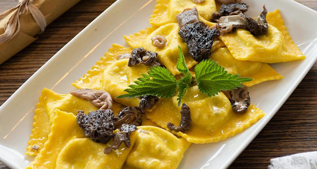 Tortelli ricotta e ortiche con funghi spugnole. Pasta fresca ripiena, piatto gourmet.