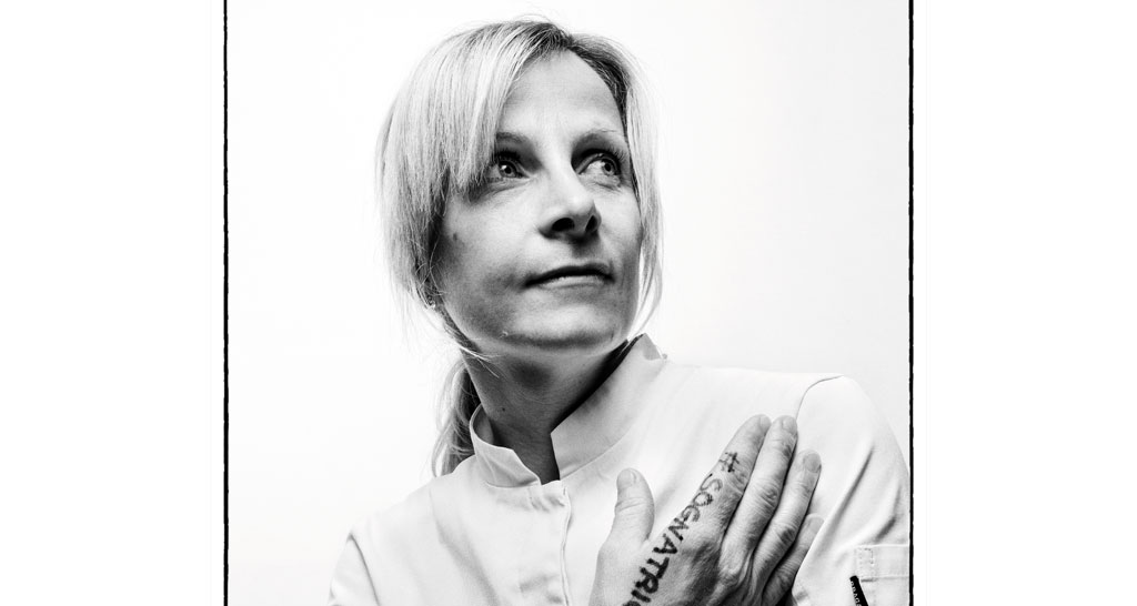 Ritratto in bianco e nero di donna bionda con hashtag #sognatrice. Chef donna, sguardo determinato.