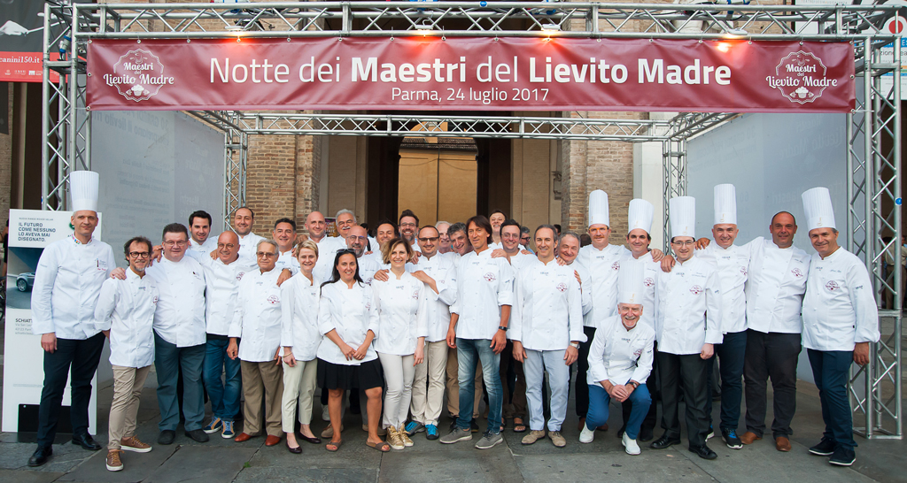 Gruppo di pasticceri alla Notte dei Maestri del Lievito Madre, Parma. Evento culinario, chef e tradizione.