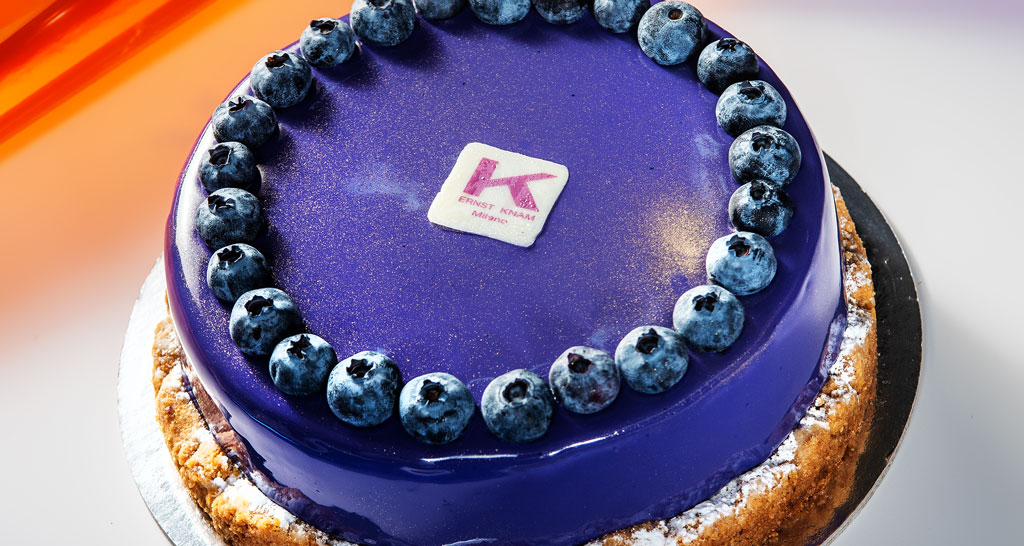 Torta Ernst Knam viola con glassa lucida e mirtilli freschi. Pasticceria artigianale.