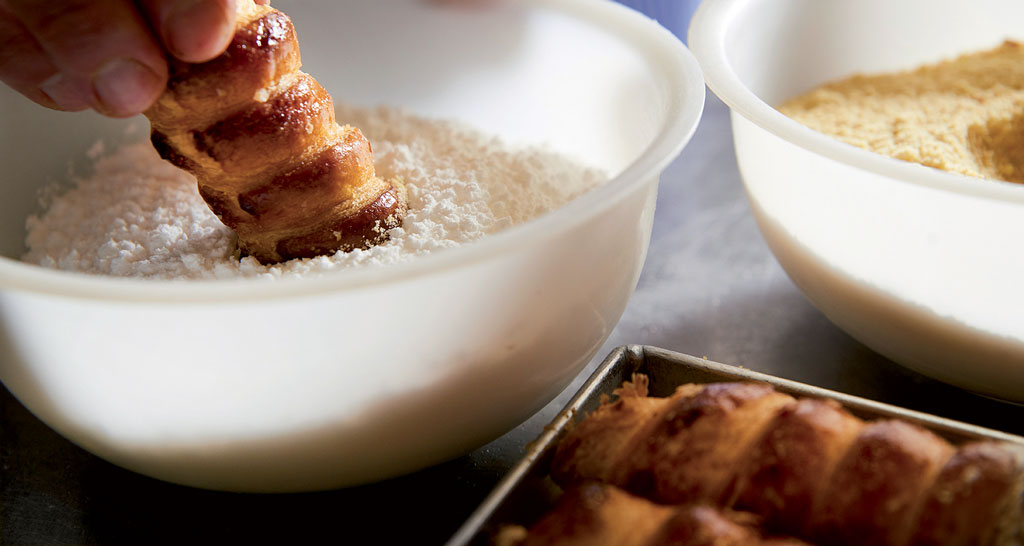 Dolce pasta sfoglia immersa nello zucchero a velo. Preparazione pasticcini, ricetta dolce.