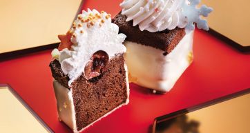 Dolci natalizi: tortine al cioccolato con panna e ciliegia. Dessert festivi, pasticceria artigianale.